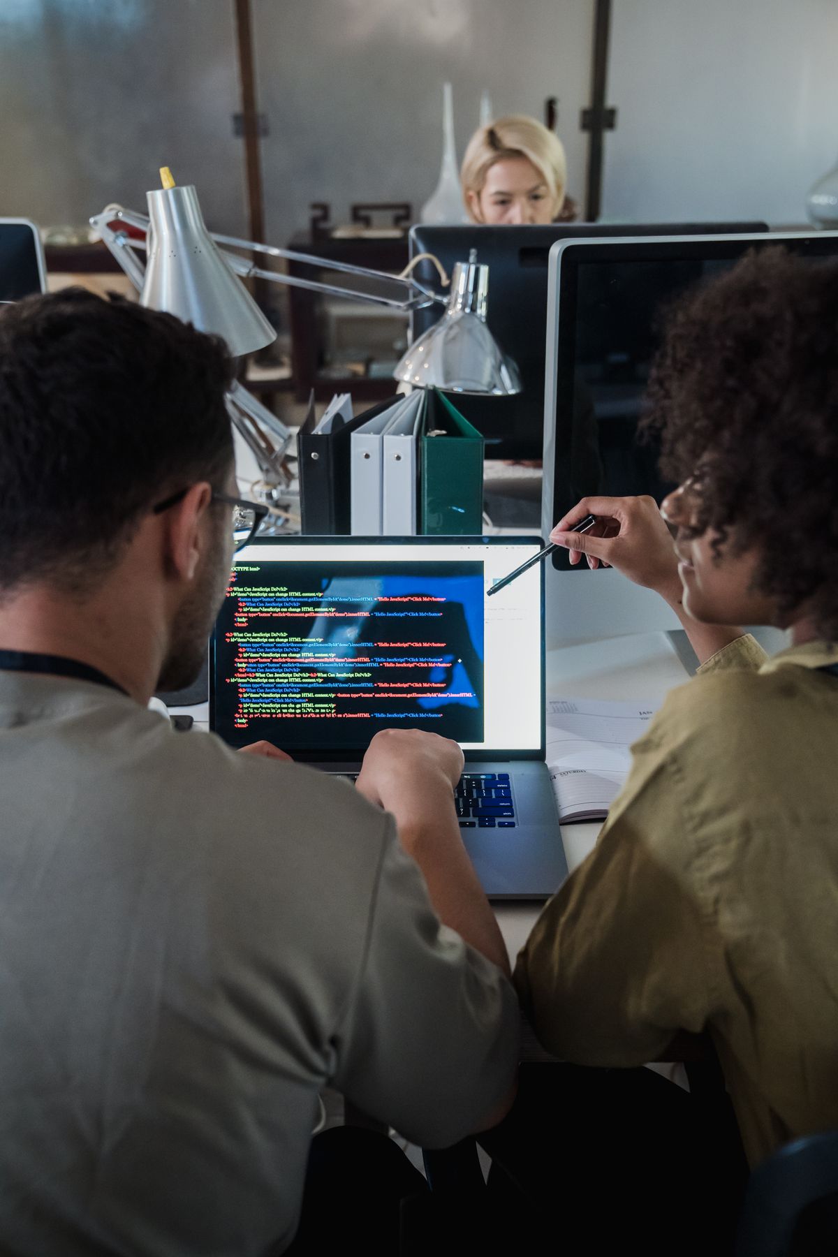 Two developers reviewing a chatbot on a laptop